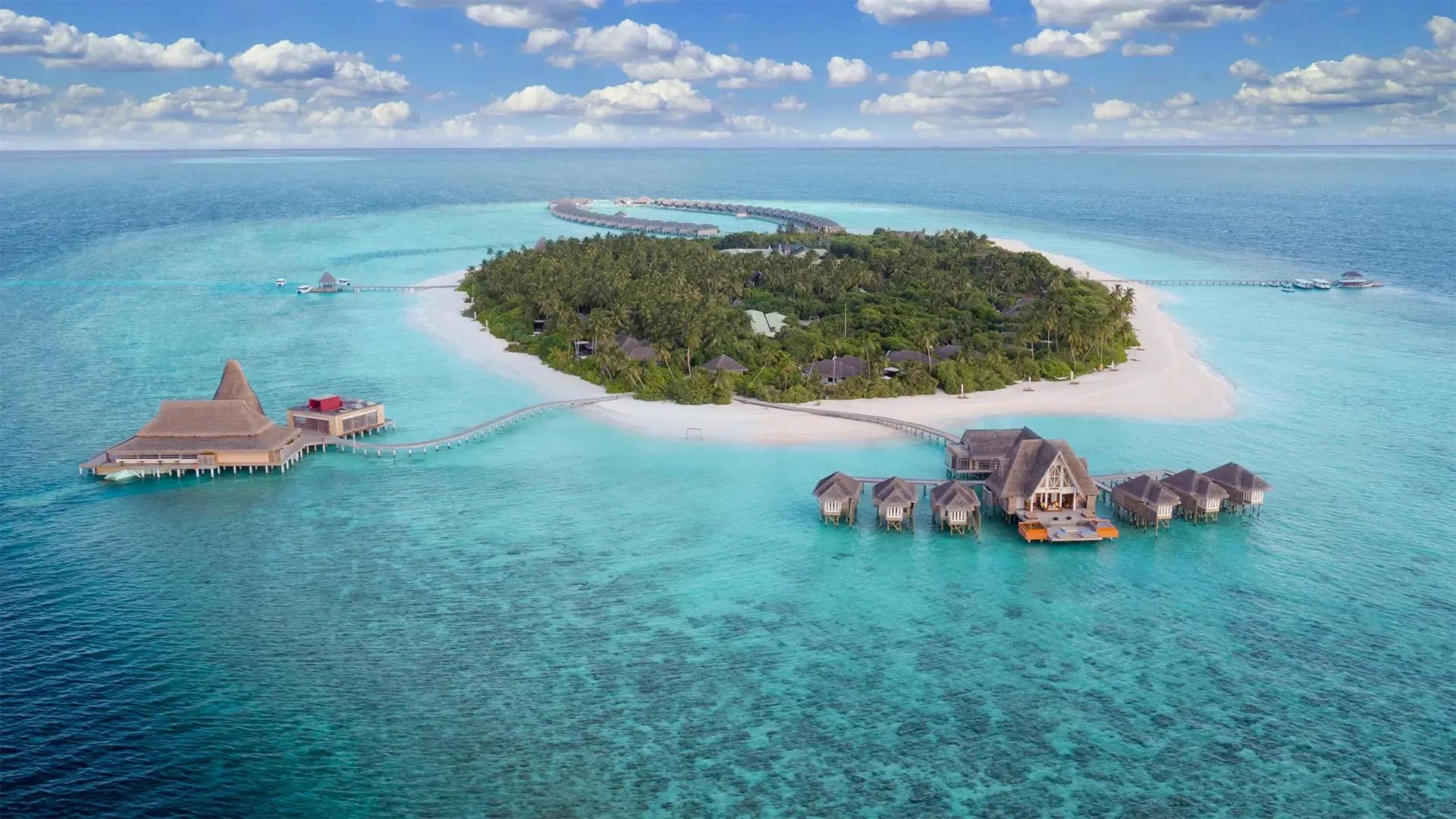 Остров и виллы на воде Anantara Kihavah под кучевыми облаками, атолл Баа, Мальдивы в мае