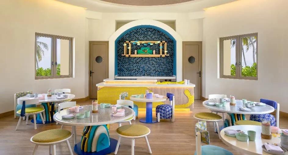 Детский ресторан Petit Bistro в Авани Фарес: круглые столы, табуреты и жёлтая стойка