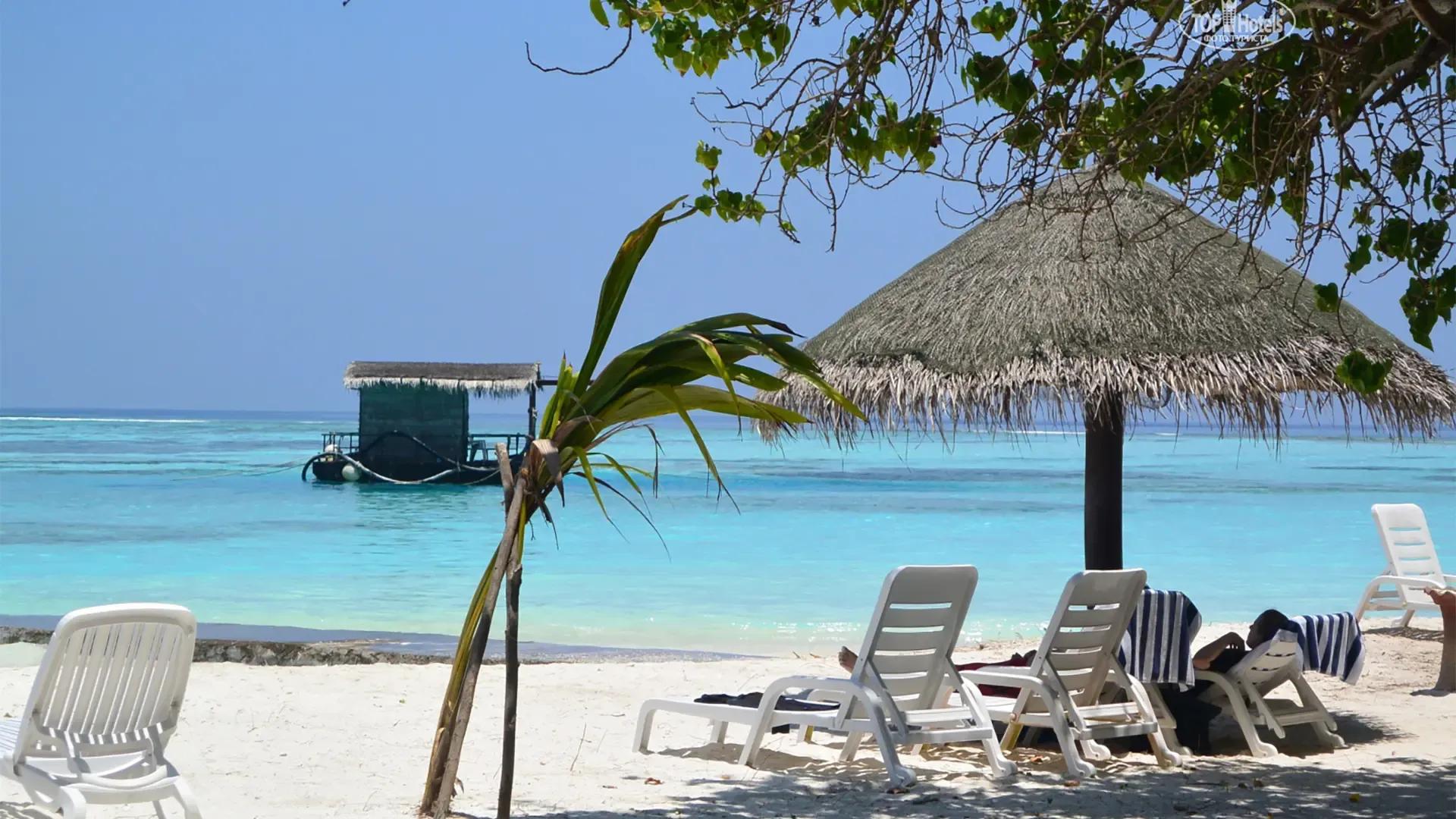 Пляж Adaaran Select Hudhuran Fushi: лежаки под соломенным зонтом и плавучий бар в лагуне, ясное утро, Северный Мале