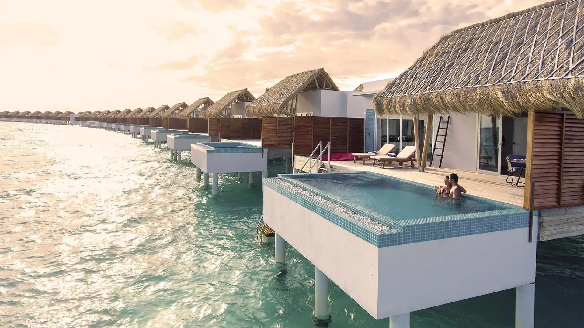 Ряд вилл на воде Emerald Maldives, рябь на лагуне и дымка над горизонтом, атолл Раа