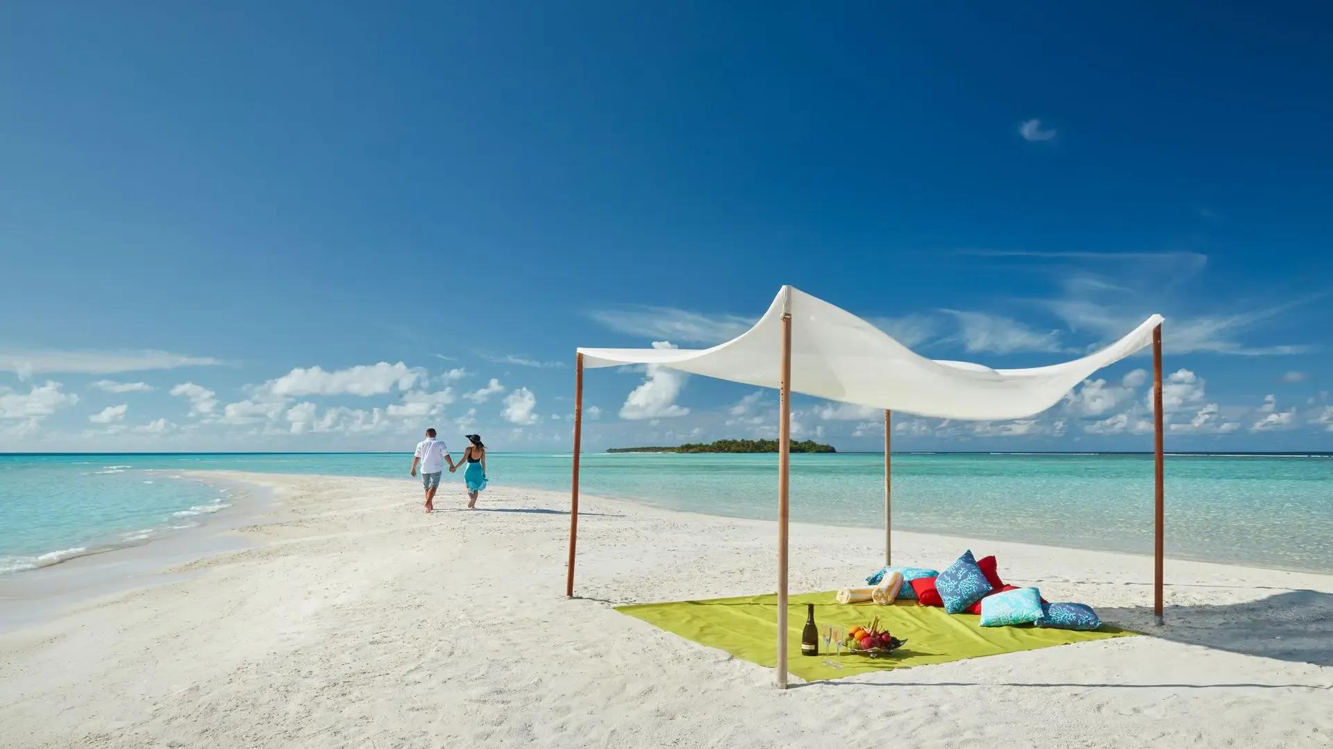 Пара идёт по песчаной косе к тенту с пикником, Kandima Maldives, атолл Даалу