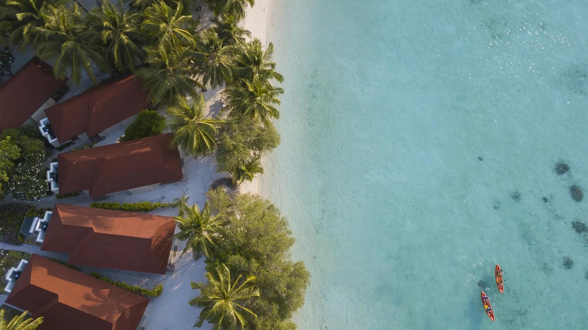 Пляжные виллы NIVA Kurumba Maldives на песке у мелкой лагуны, атолл Каафу, вид сверху