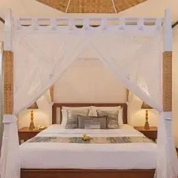 Deluxe Beachfront в Бандосе: кровать с балдахином и светлые стены