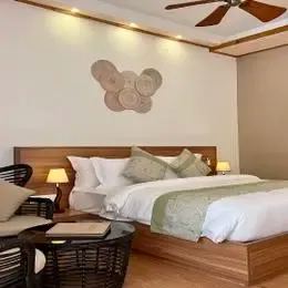 Вилла на пляже Bougain Villa: кровать, кресла у окна и деревянный пол