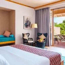 Beach Villa: кровать, бирюзовый диван вдоль стены и раздвижные двери на террасу