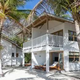 Duplex Garden Bungalow на Донвели: белый двухэтажный домик с балконом под пальмами