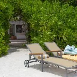 Beach Villa: лежаки с полотенцем у входа среди кустов на песке