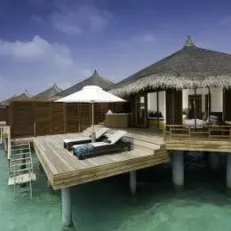 Water Villa на Курамати: терраса с зонтом и лестницей в бирюзовую лагуну