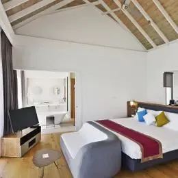 Deluxe Water Villa на Курамати: кровать и диван у панорамных окон