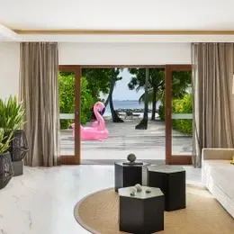 Гостиная Family Villa в Курумбе: белый диван и открытые двери к пляжу