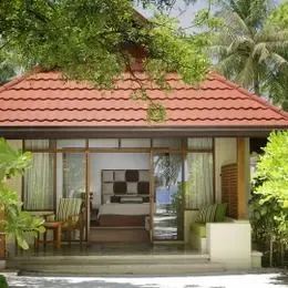 Beach Villa в Курумбе снаружи: бунгало с красной крышей и террасой в зелени