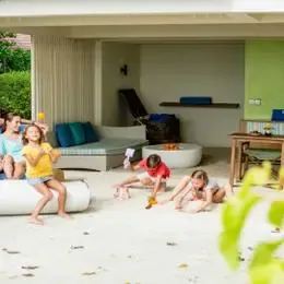 Garden Villa на Кандуме: деревянная беседка на песке перед домом, рядом семья